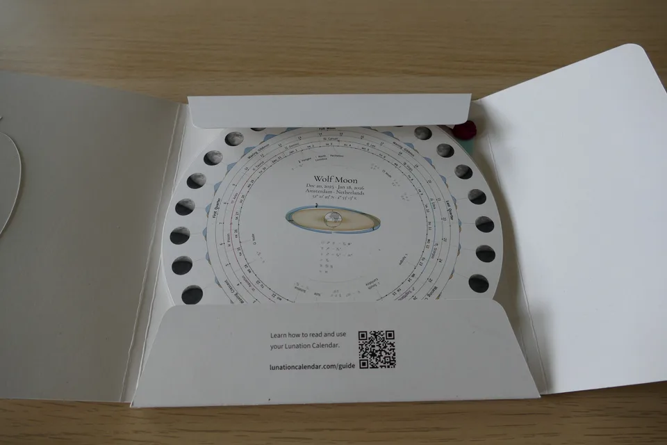 Prototype package opened to reveal a circular Wolf Moon chart and a printed link to the reading guide.
